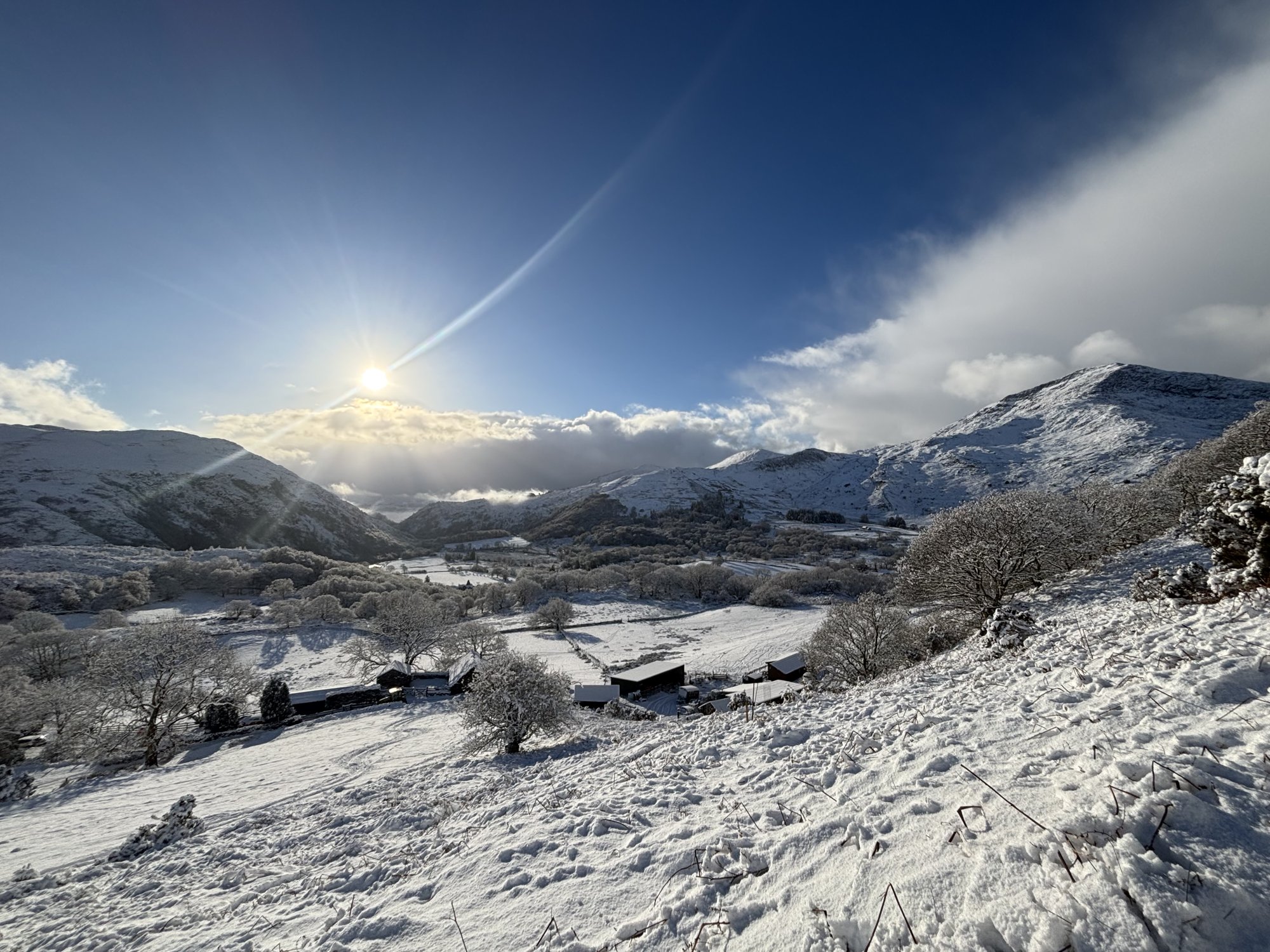 Winter sunshine over snow-covered fields and mountain slopes